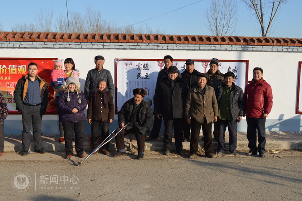 与村民在共建文化墙前合影